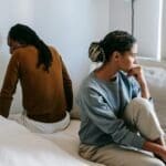 frustrated couple on bed with marriage problems